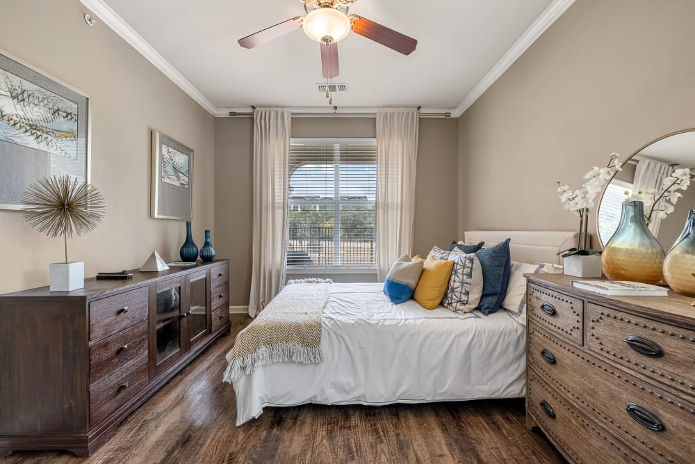 Bright bedroom with wood floors and a ceiling fan at Marquis at Crown Ridge in San Antonio, Texas