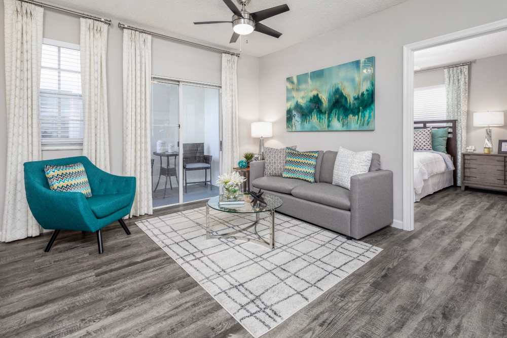 Apartment living room with hardwood flooring, sofa, and ceiling fan at Nova Central Apartments in Davie, Florida