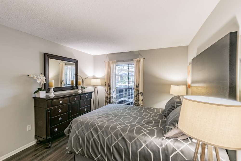 Apartment bedroom with full-size bed and dresser at Legend Oaks in Tampa, Florida