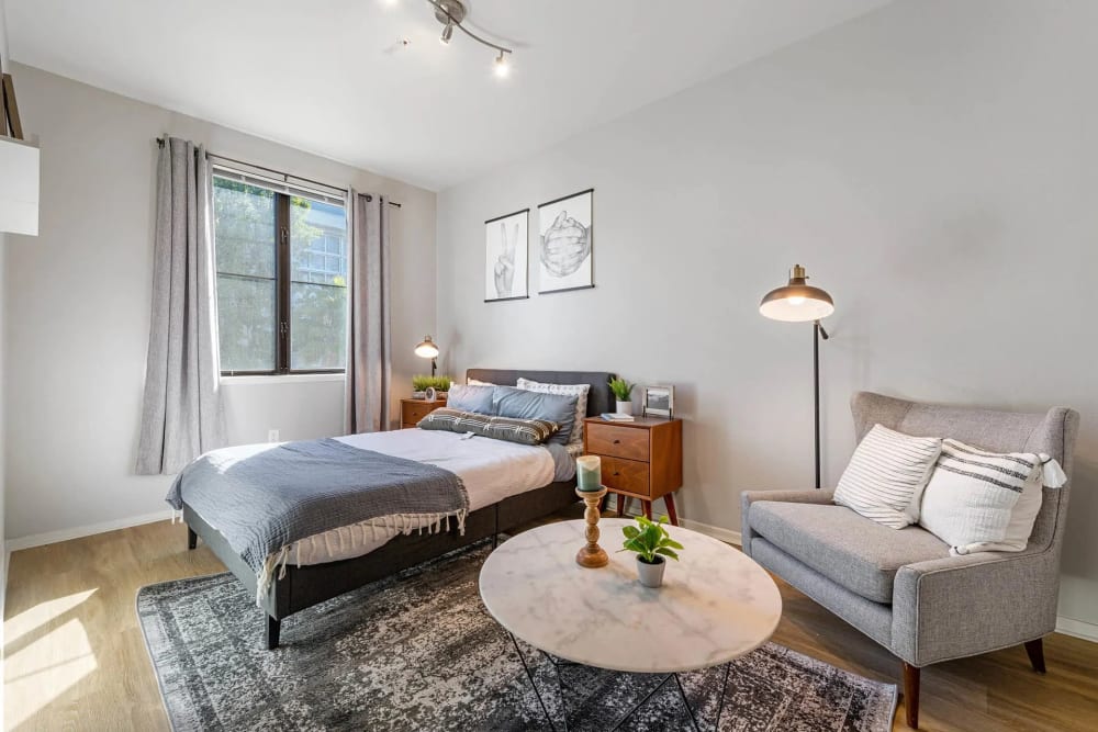 Spacious bedroom with wood-style flooring and warm, neutral paint scheme at K Street Flats in Berkeley, California