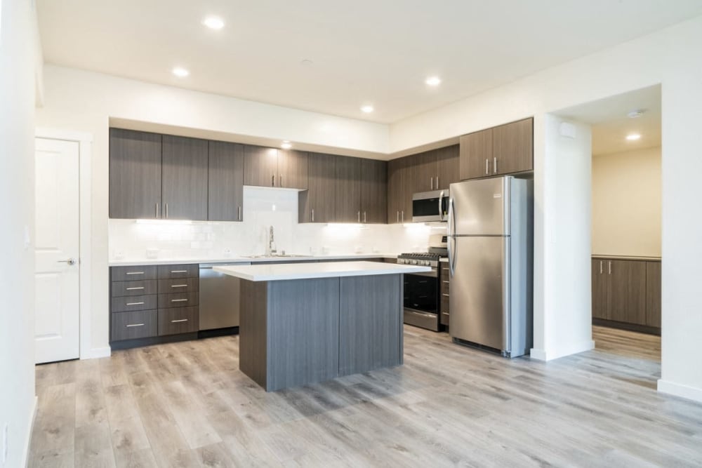 White cupboards and stainless-steel appliances in an apartment kitchen at Hub Apartments in Folsom, California