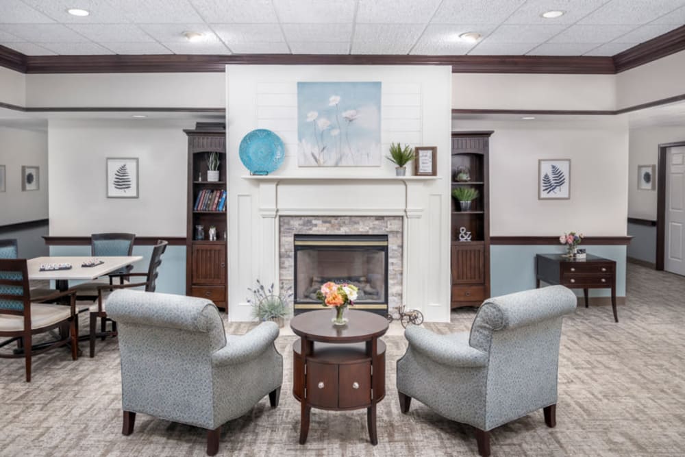 Lounge with a bookshelf and fireplace at Governor's Pointe in Mentor, Ohio