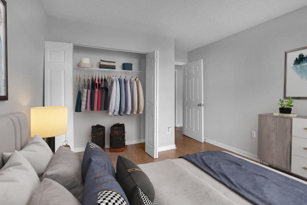 An apartment bedroom with the closet doors open at Five7Five in Austell, Georgia
