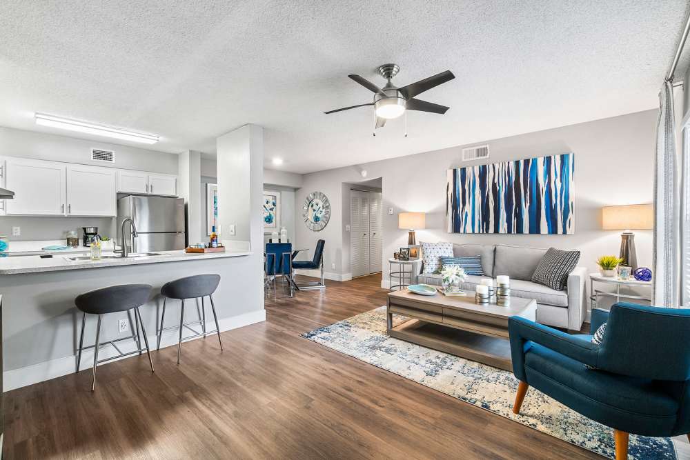 Apartment living room with hardwood floors, sofa, and wooden coffee table at Boynton Place Apartments in Boynton Beach, Florida