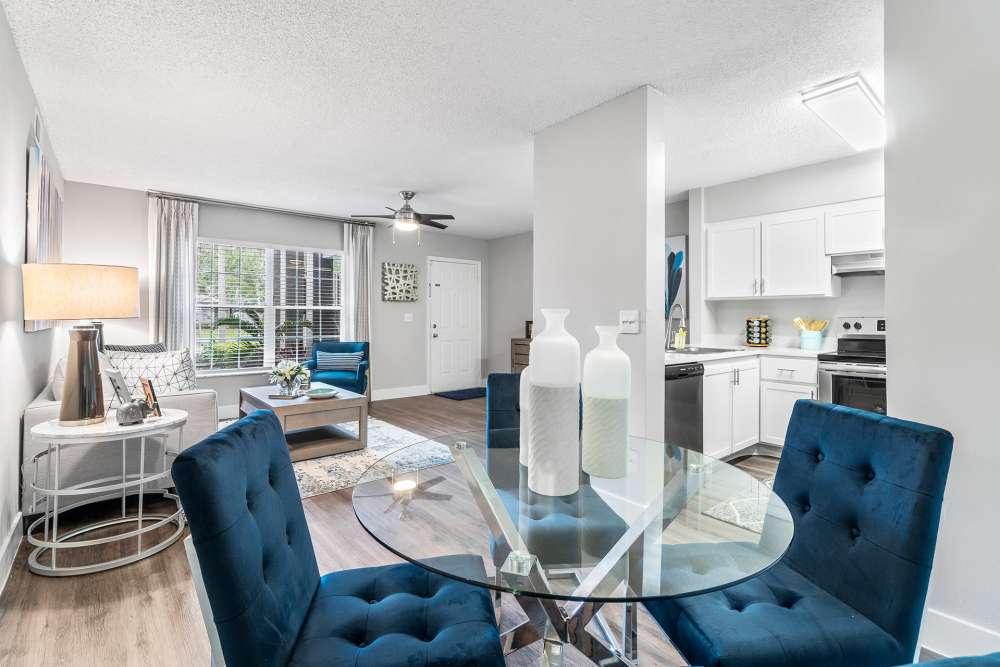 Apartment dining area with glass table and upholstered chairs at Boynton Place Apartments in Boynton Beach, Florida