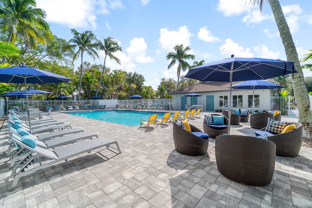 Lots of patio furniture seating by the pool at Boynton Place Apartments in Boynton Beach, Florida