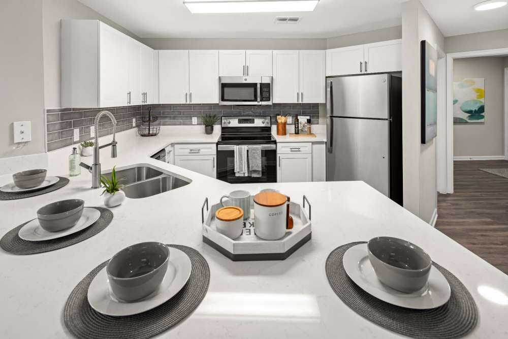 Apartment kitchen with counter seating and stainless steel appliances at Pointe Parc at Avalon in Orlando, Florida