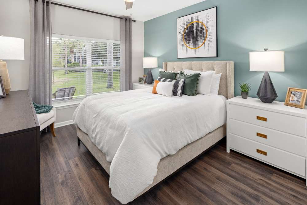 Large apartment bedroom with hardwood floors and matching end tables at Pointe Parc at Avalon in Orlando, Florida