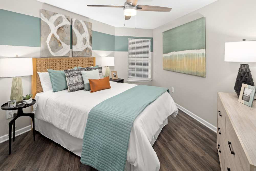 Apartment bedroom with full-size bed and hardwood floors at Pointe Parc at Avalon in Orlando, Florida