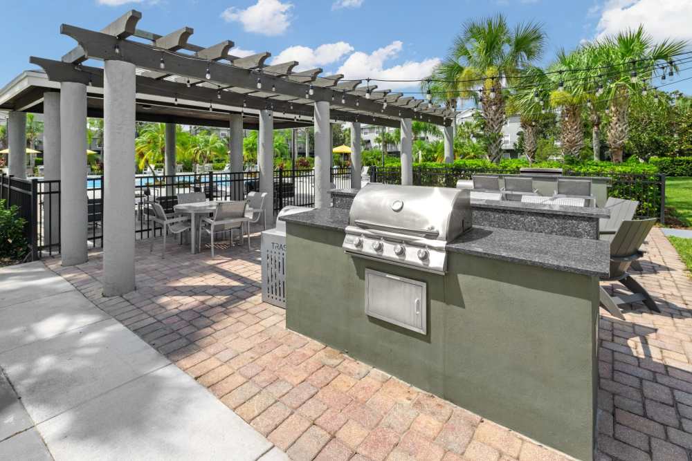 Outdoor kitchen with grills and seating at Pointe Parc at Avalon in Orlando, Florida