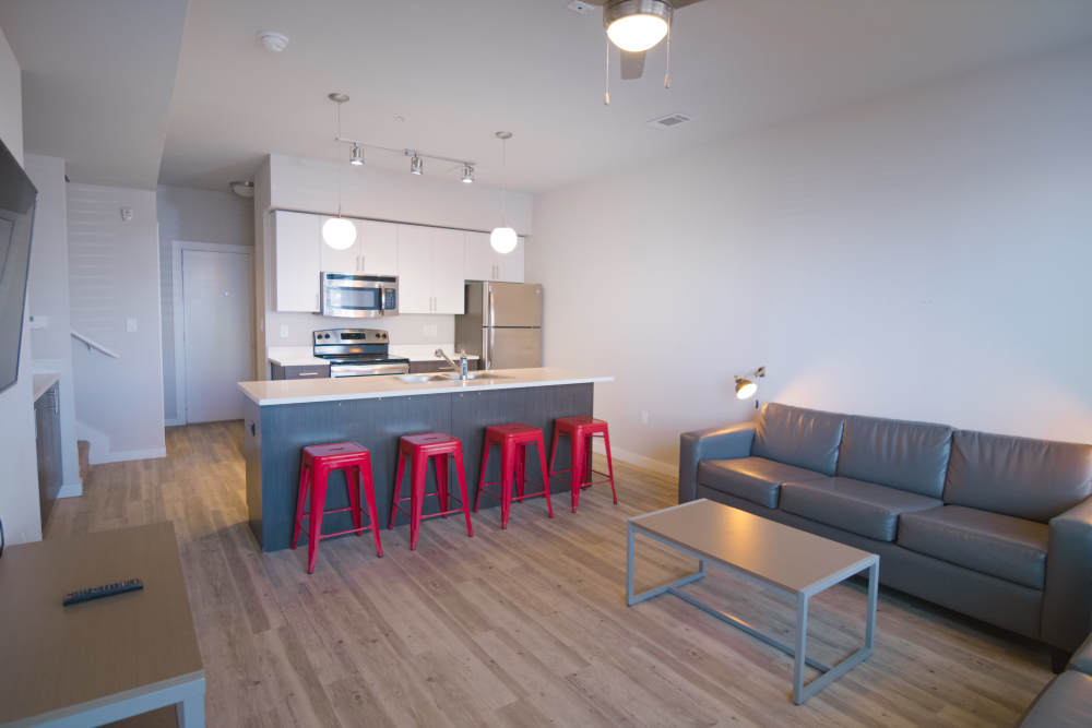 Living room with hardwood floors and leather sofa at College Town Fayetteville in Fayetteville, Arkansas