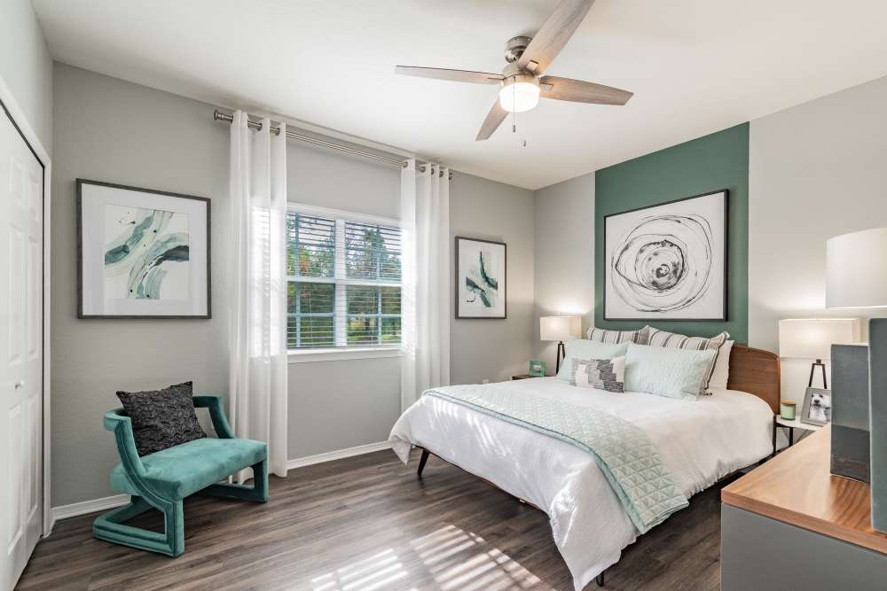Apartment bedroom with ceiling fan and matching end tables at The Parq at Cross Creek in Tampa, Florida