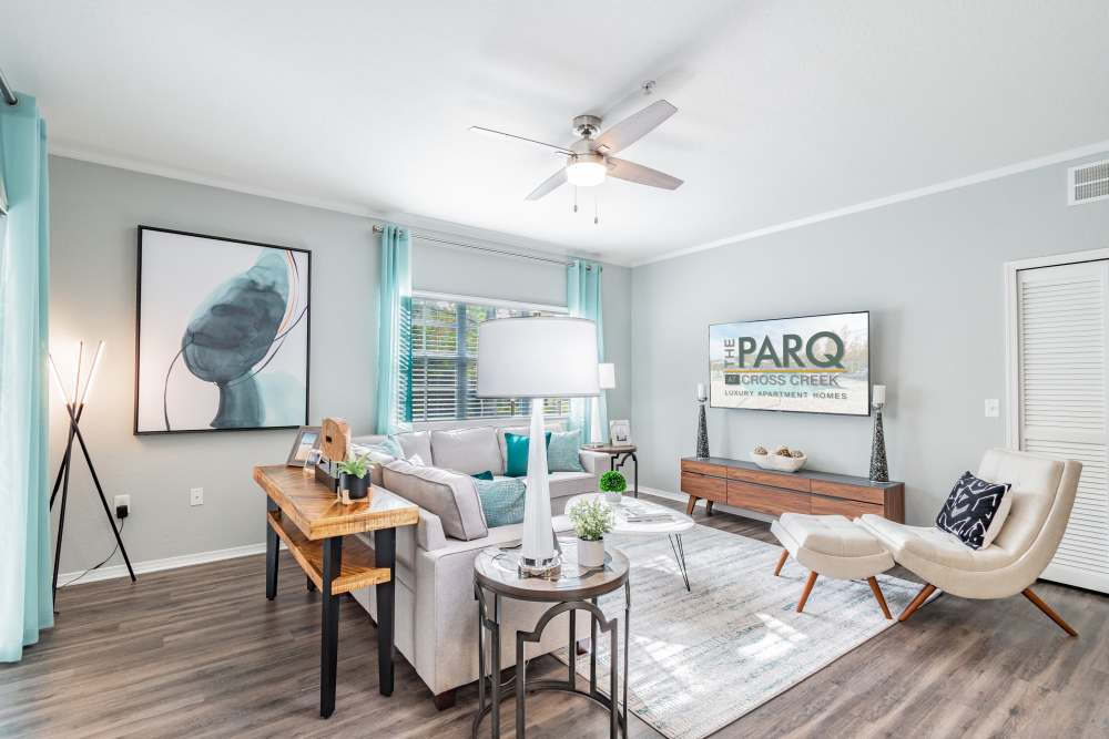 Apartment living room with large area rug and sectional sofa at The Parq at Cross Creek in Tampa, Florida