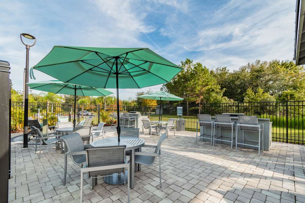 Tables and chairs with umbrellas by the pool at The Parq at Cross Creek in Tampa, Florida