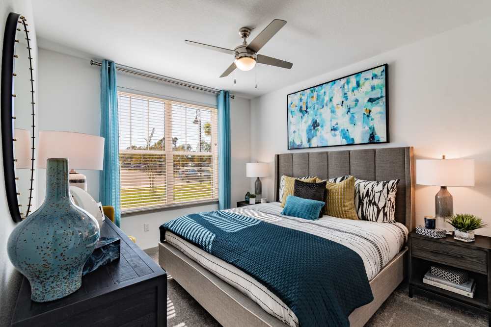 Apartment bedroom with large sunlit window and queen-size bed at Vue on Lake Monroe in Sanford, Florida