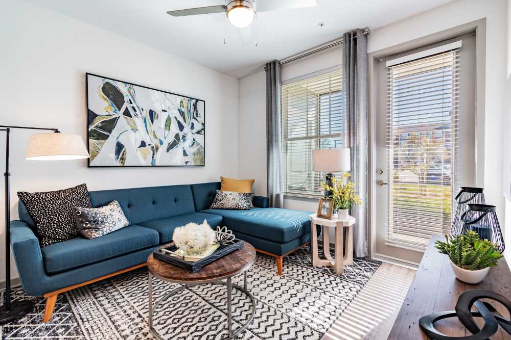 Cozy apartment living room with large area rug and sectional sofa at Vue on Lake Monroe in Sanford, Florida