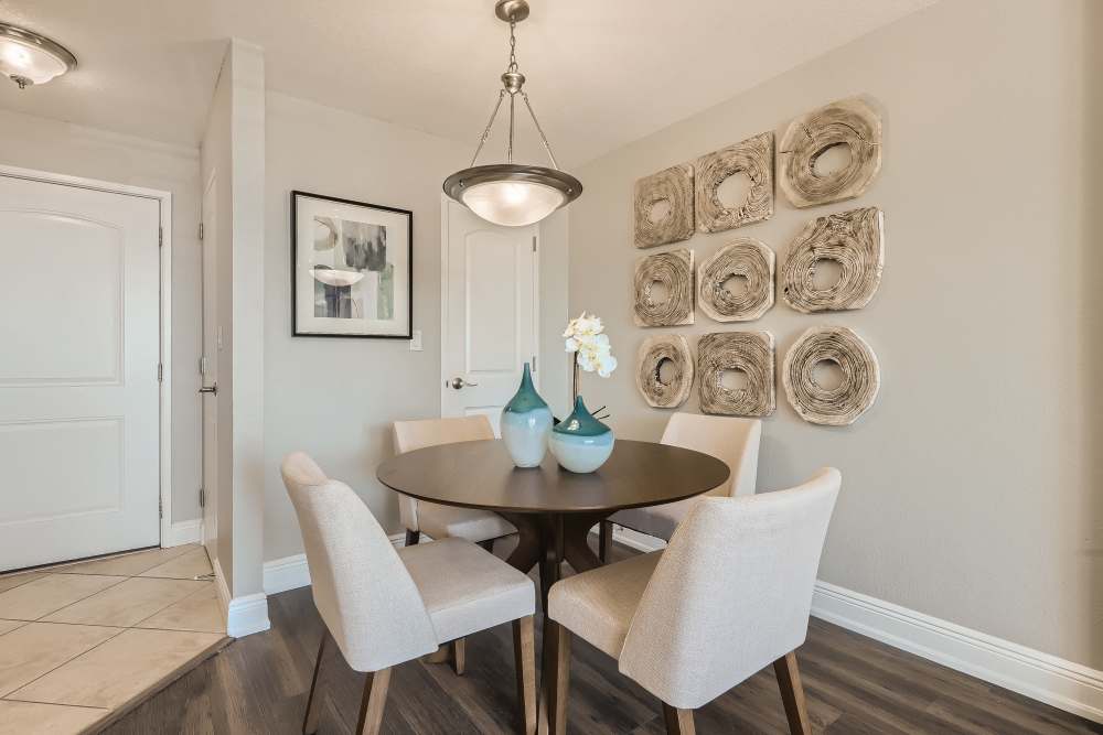 Apartment dining area with table and upholstered chairs at Waters Pointe in South Pasadena, Florida