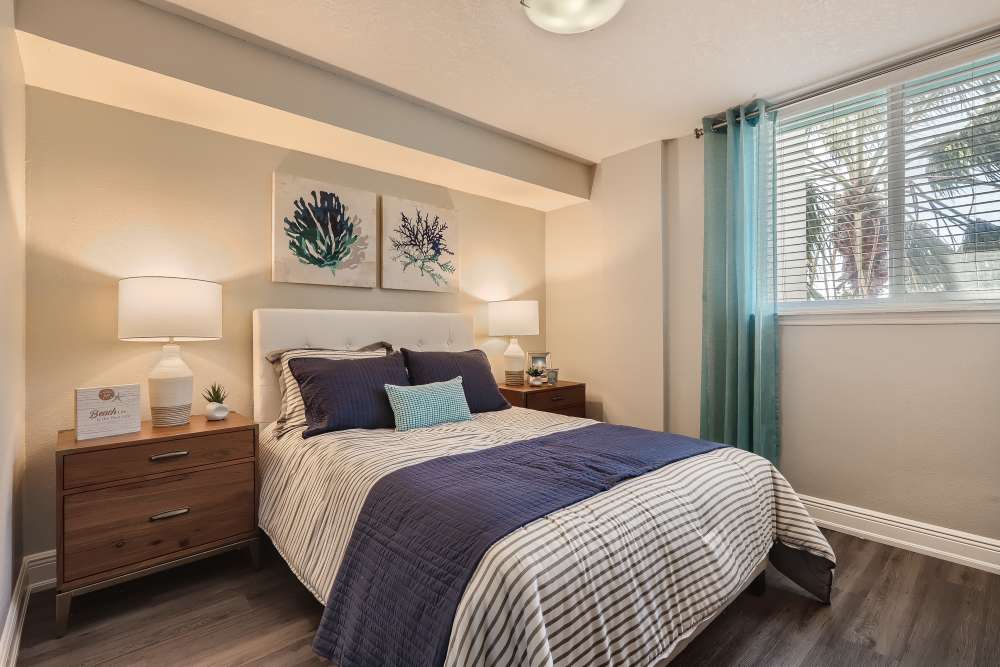 Apartment bedroom with hardwood floors and queen size bed at Waters Pointe in South Pasadena, Florida