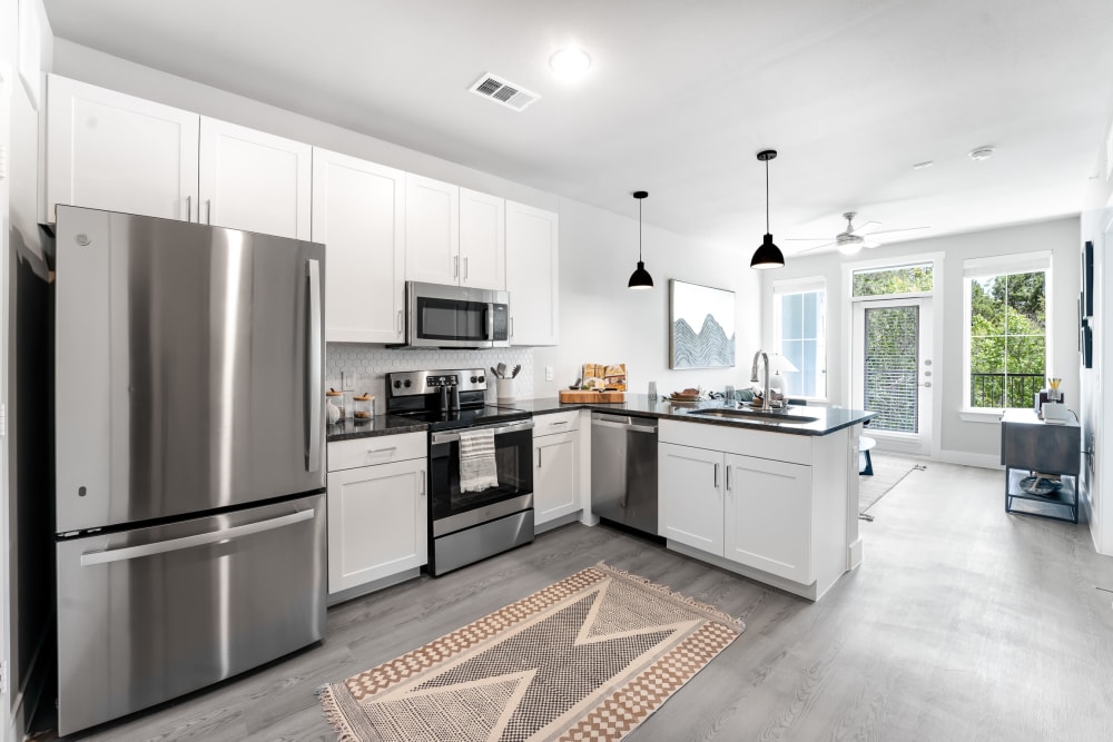 luxury one bedroom kitchen with stainless steel appliances and white cabinetry at  The Bennett in Austin, Texas
