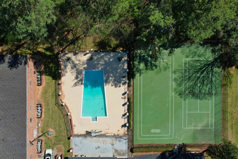An aerial view of the swimming pool and tennis court at Rivers Edge Apartments in Jonesboro, Georgia