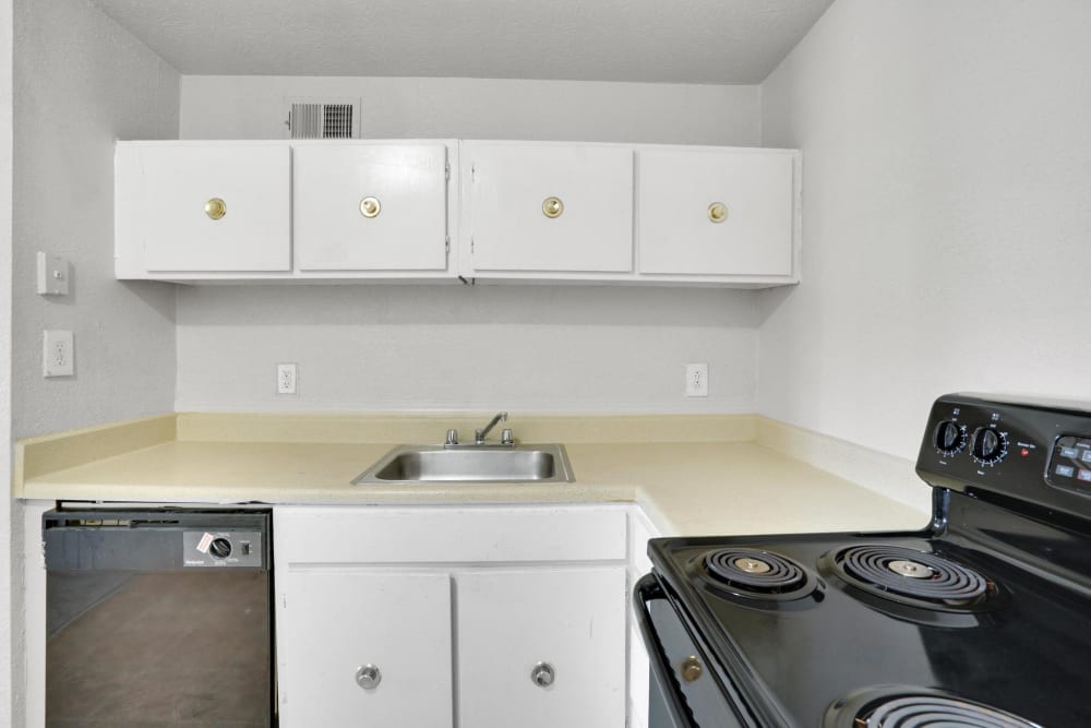 White cabinets and black appliances in an apartment kitchen at Rivers Edge Apartments in Jonesboro, Georgia