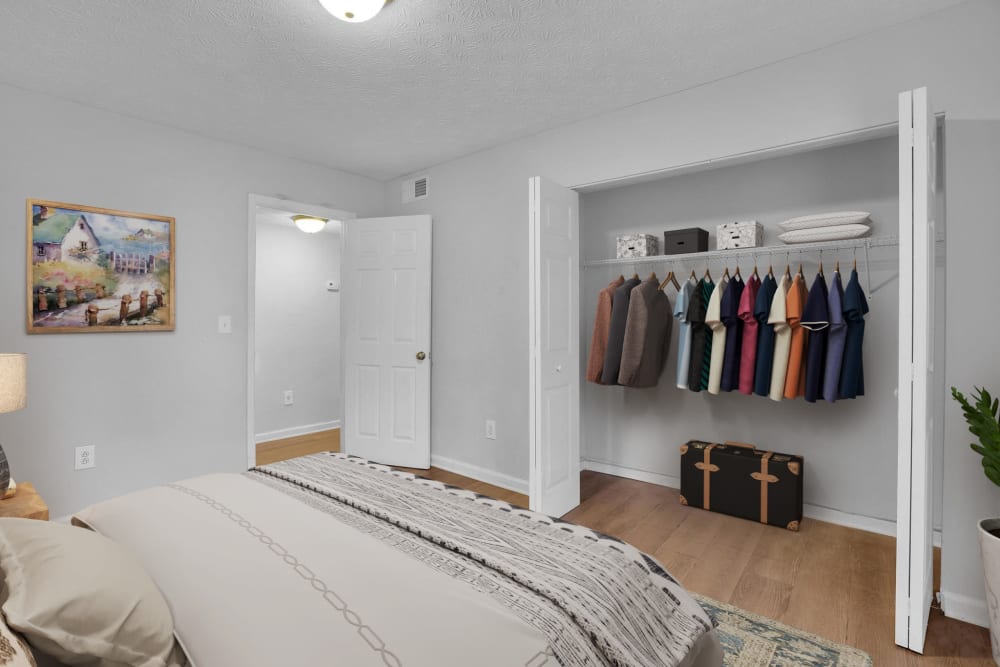 An apartment bedroom with the closet doors open at Residence at Riverside in Austell, Georgia