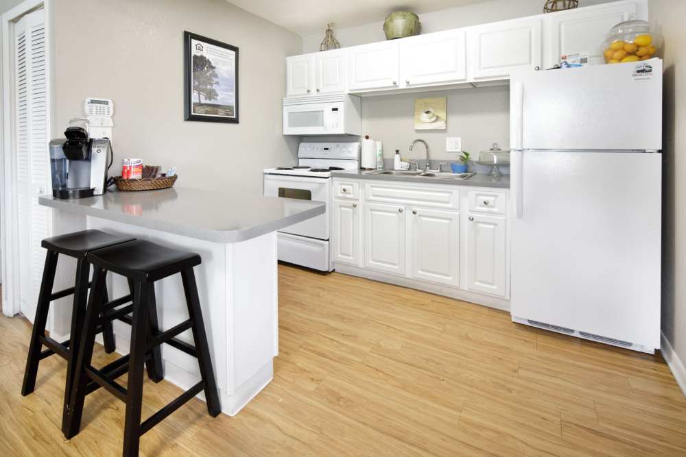 Apartment kitchen with counter seating and hardwood floors at Windward Apartments in Orlando, Florida