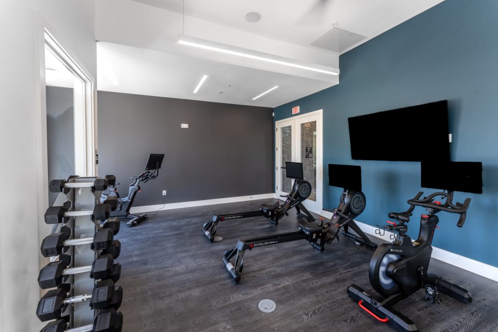 Fitness center with spin bikes and rowers and free weights at The Bennett in Austin, Texas