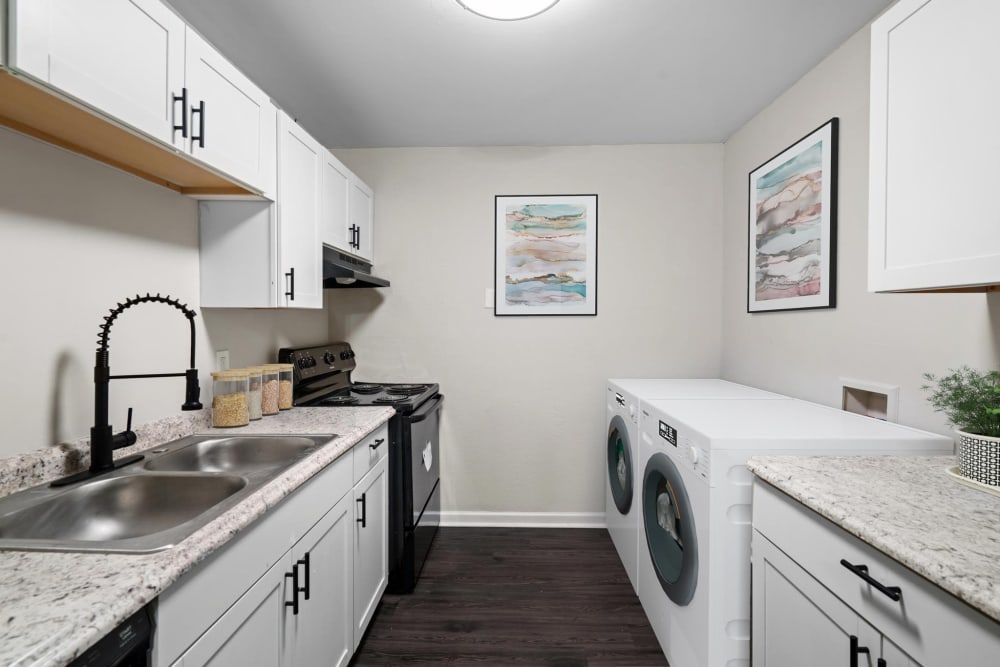 An apartment kitchen with a washer and dryer at Spring Creek Apartment Homes in Decatur, Georgia