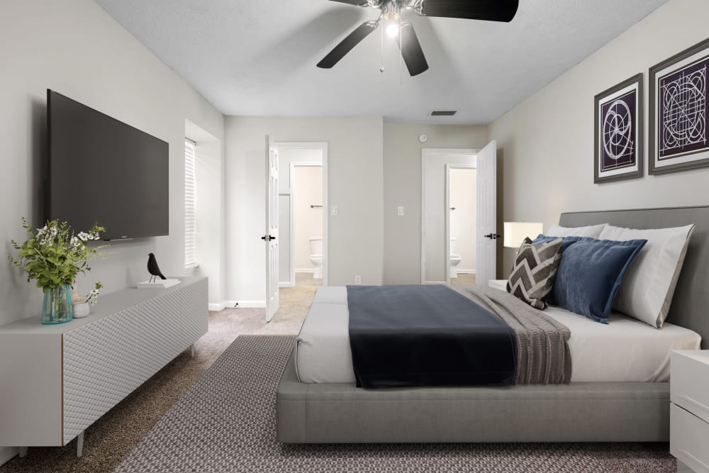 A furnished main bedroom with an attached bathroom at Spring Creek Apartment Homes in Decatur, Georgia