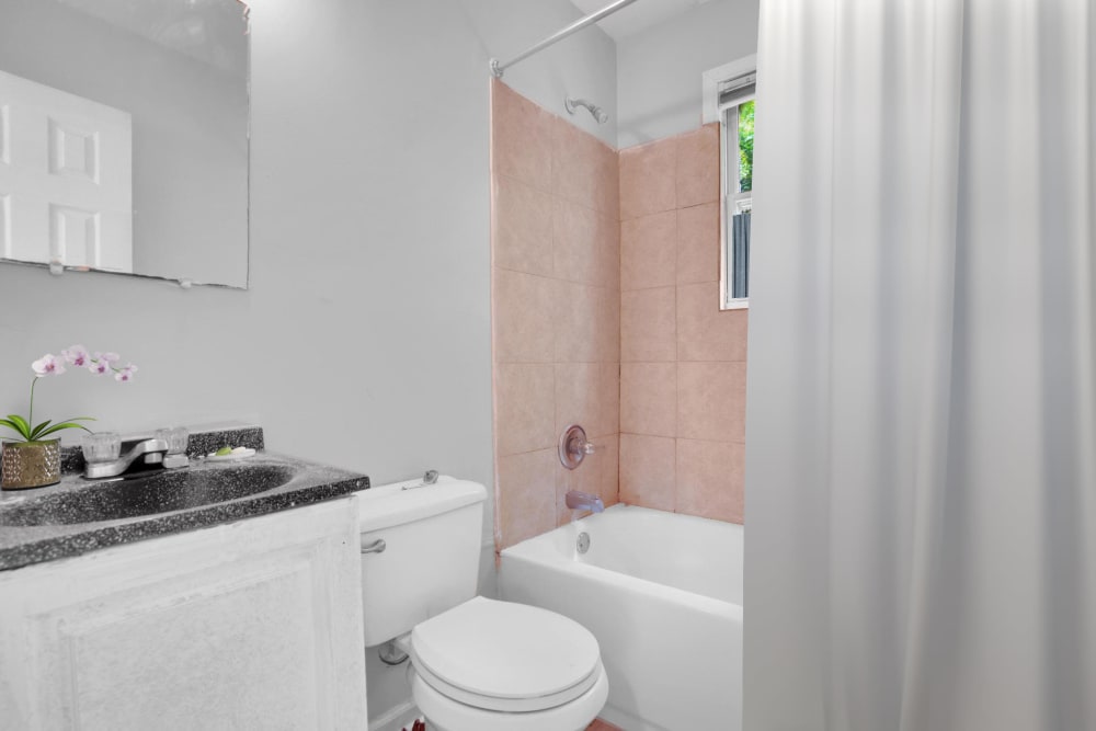 A bathtub and white cabinets in an apartment bathroom at Stanton View Apartments in Atlanta, Georgia