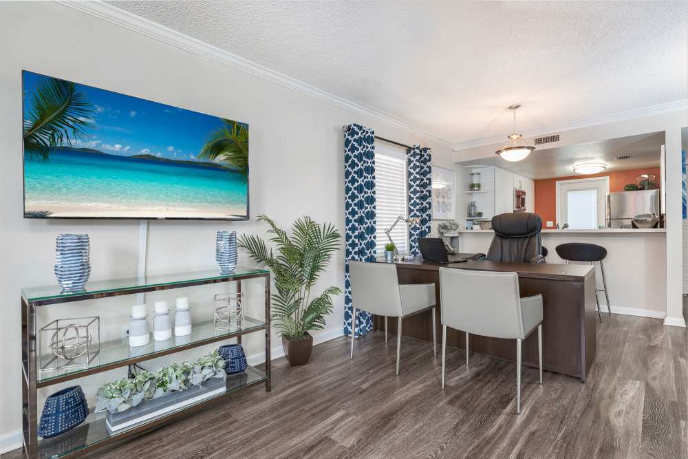 Furnished living room with entertainment center and dining area at Barrington Place at Winter Haven in Winter Haven, Florida