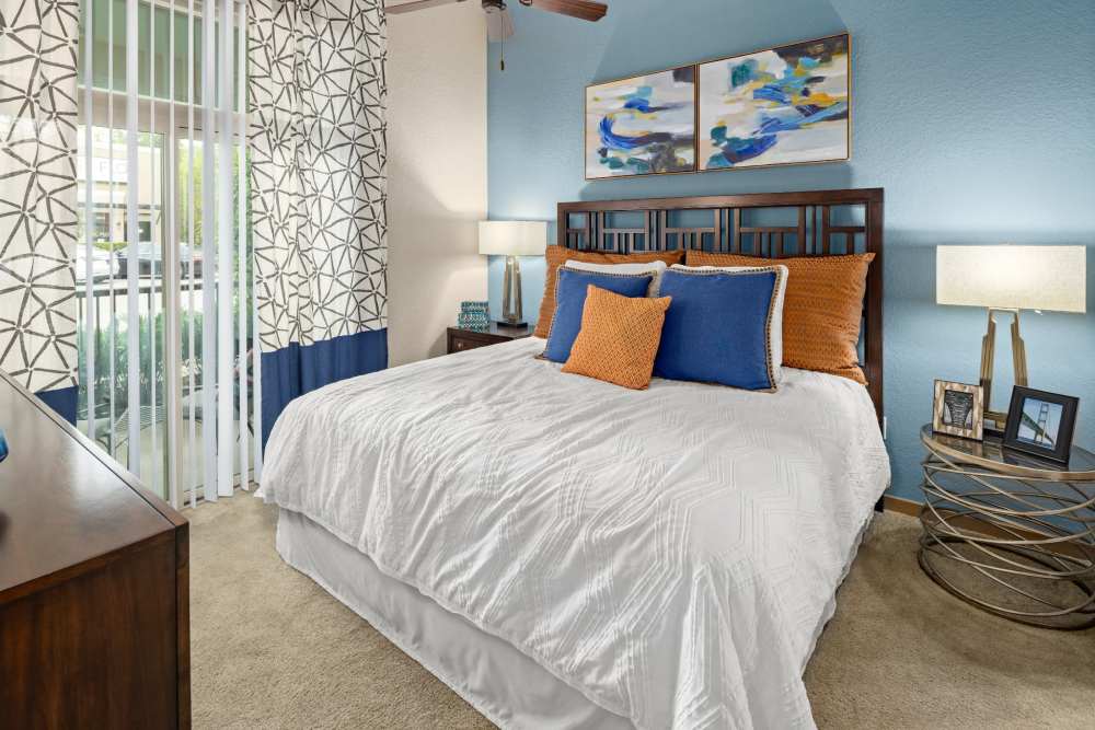 Carpeted apartment bedroom with balcony access at Station House at Lake Mary in Lake Mary, Florida