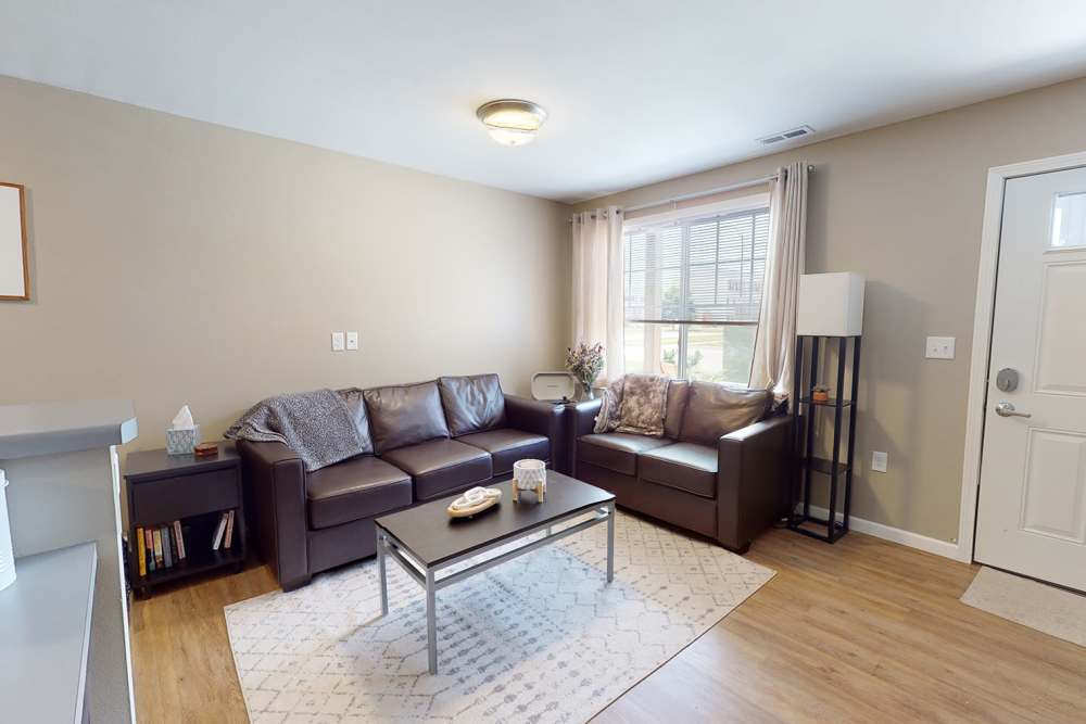 Living room with leather sofa at The Quarters at Ames in Ames, Iowa