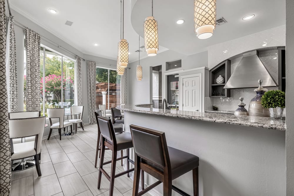 Community clubhouse kitchen and dining area with large windows at Marquis at Stonegate in Fort Worth, Texas