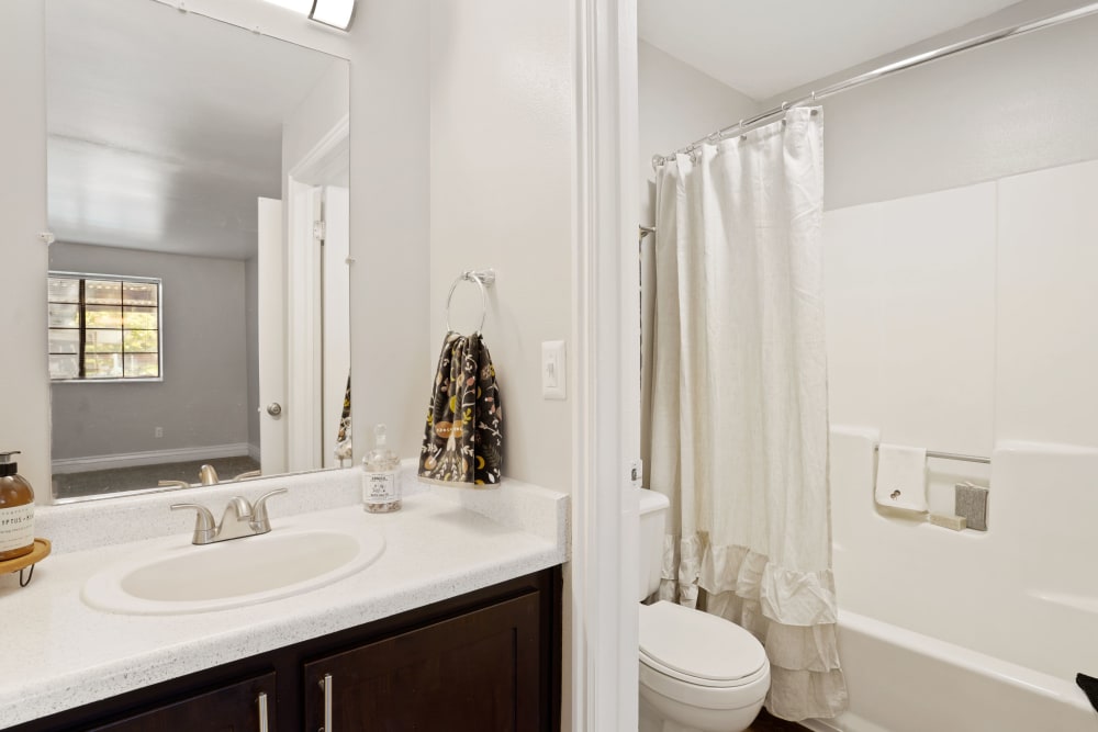 Decorated bathroom with brown cabinets at Royal Ridge Apartments in Midvale, Utah