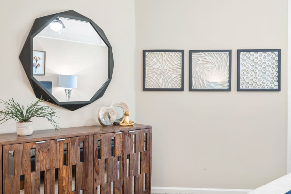 Artistically build cabinet and an octagon-shaped mirror with abstract arts in-framed at Villas at Houston Levee East Apartments in Cordova, Tennessee