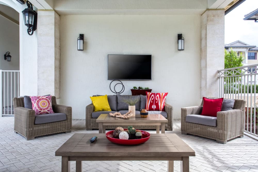 Outdoor lounge with leather furniture and television at Shalimar at Davie in Davie, Florida