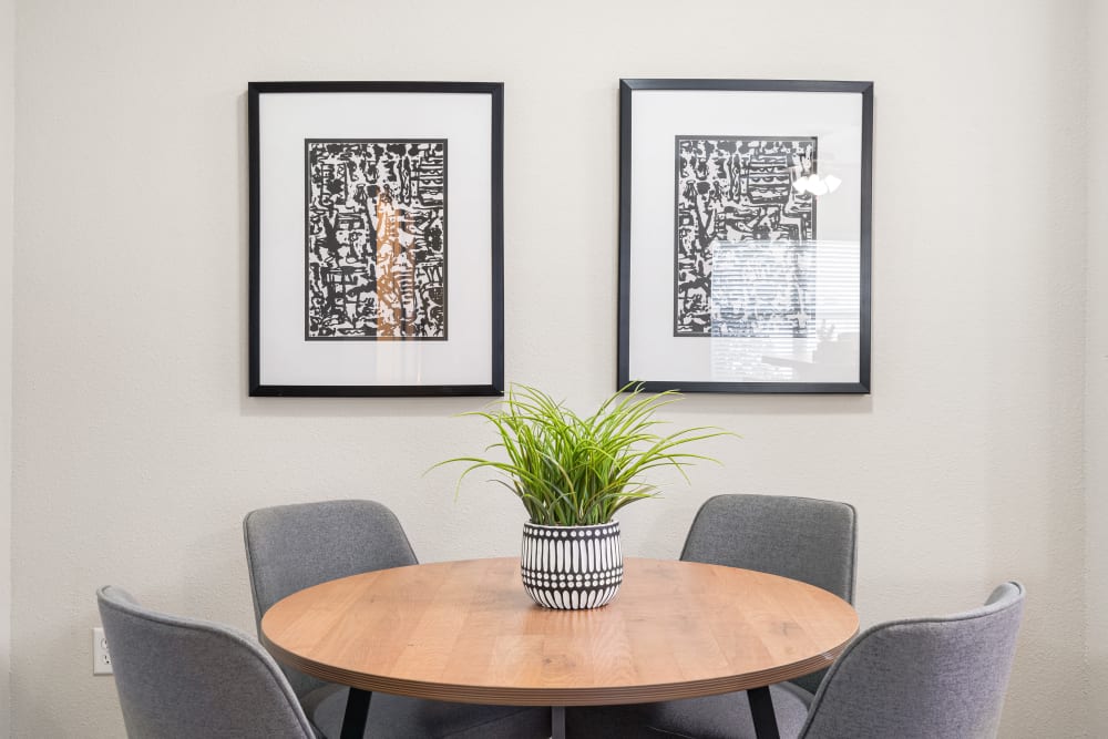 Table and chairs and two beautiful artworks on the wall at Villas at Houston Levee West Apartments in Cordova, Tennessee