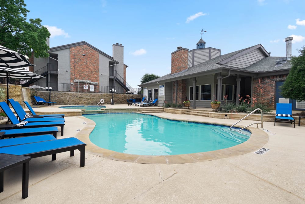 Lounge chairs by the resort-style swimming pool at The Carling on Frankford in Carrollton, Texas