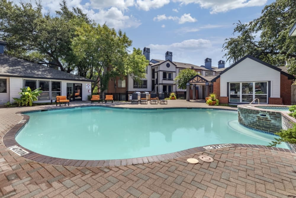 Resort-style swimming pool with poolside lounge chairs at Somerset in Lewisville, Texas