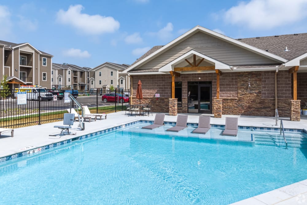 Apartments for Rent in South Kansas City MO - Forest Ridge Villas - Pool with In-Pool Loungers Surrounded By Lounge Chairs.