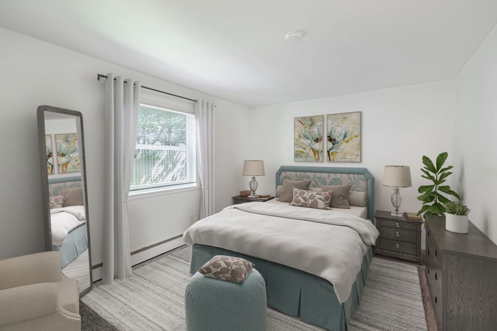 Bedroom with wall to wall carpeting and one large window at Edgewater Gardens Apartment Homes in Long Branch, New Jersey