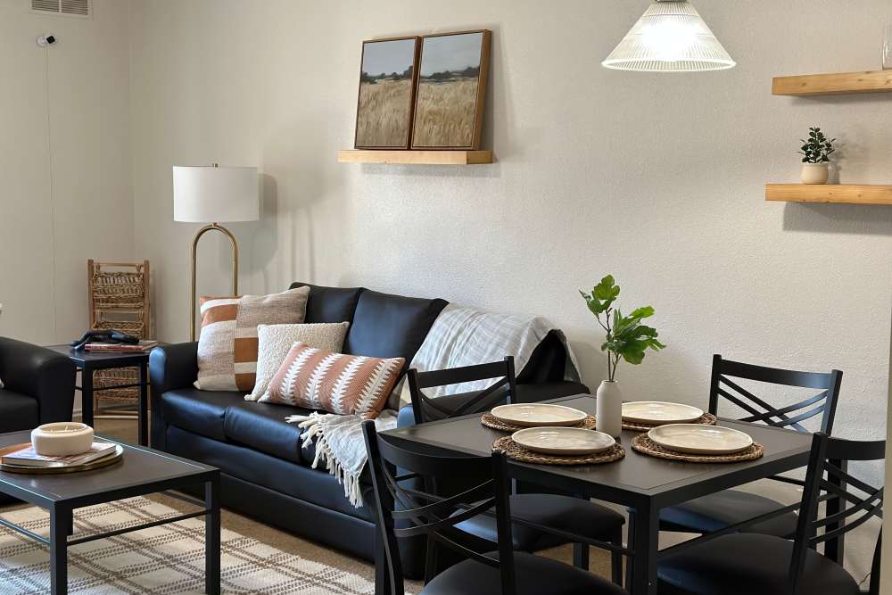 Living room with leather sofa and dining area at The Quarters at Lawrence in Lawrence, Kansas