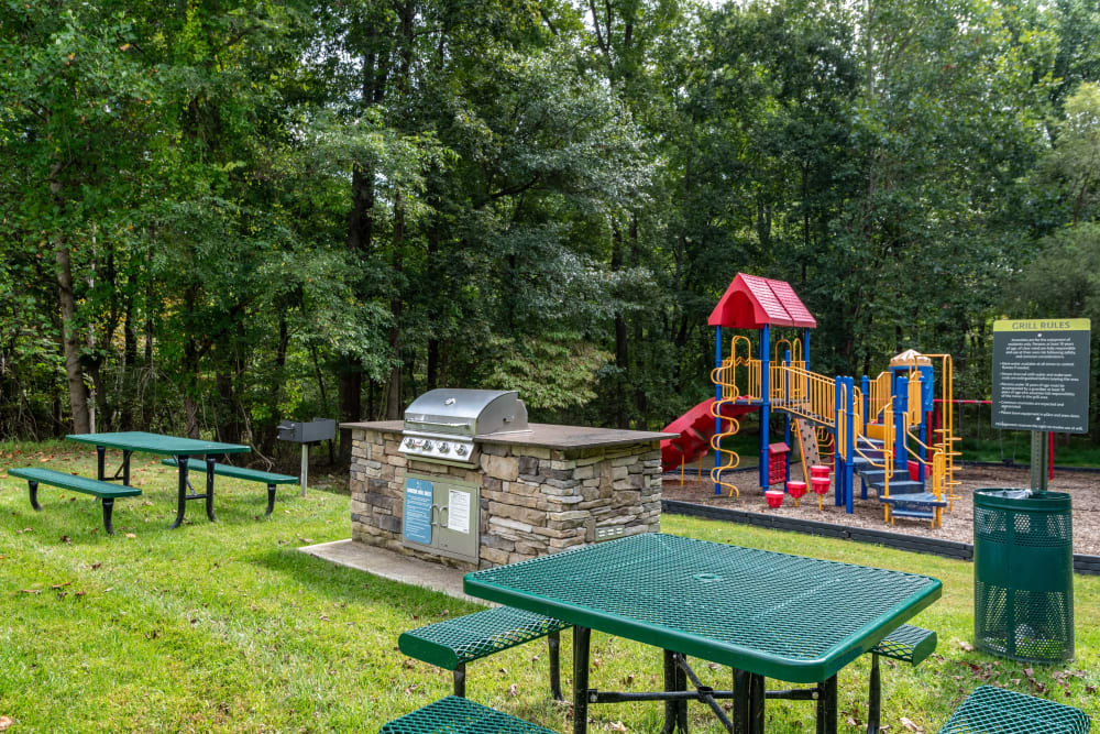 Picnic table by community playground and BBQ stations at Park at Winterset Apartments in Owings Mills, Maryland.