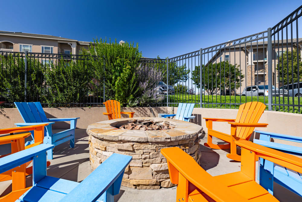 Brightly colored Adirondack chairs around a community fire pit at Meadowbrook Station Apartments in Salt Lake City, Utah