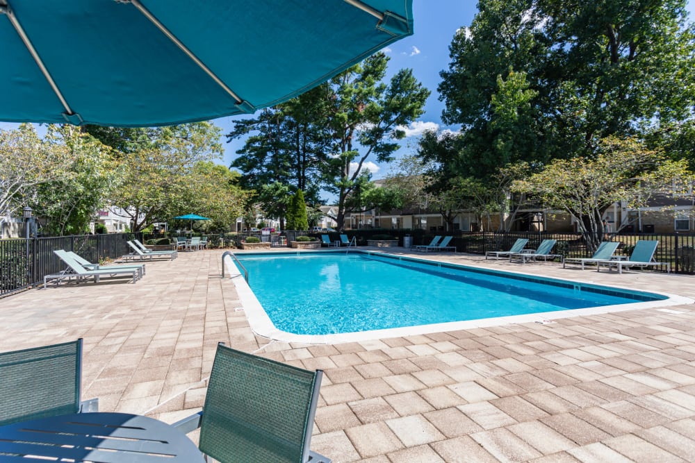 Poolside patio table with umbrella and chairs at 865 Bellevue Apartments in Nashville, Tennessee.