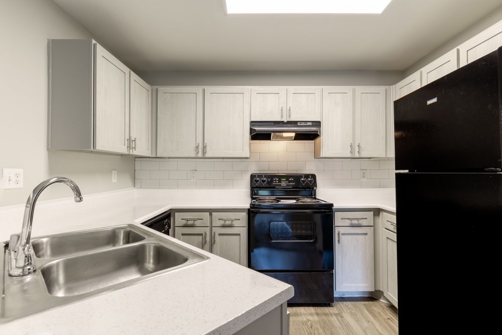 Modern kitchen with white countertops and cabinets in an apartment at Cloverbasin Village in Longmont, Colorado
