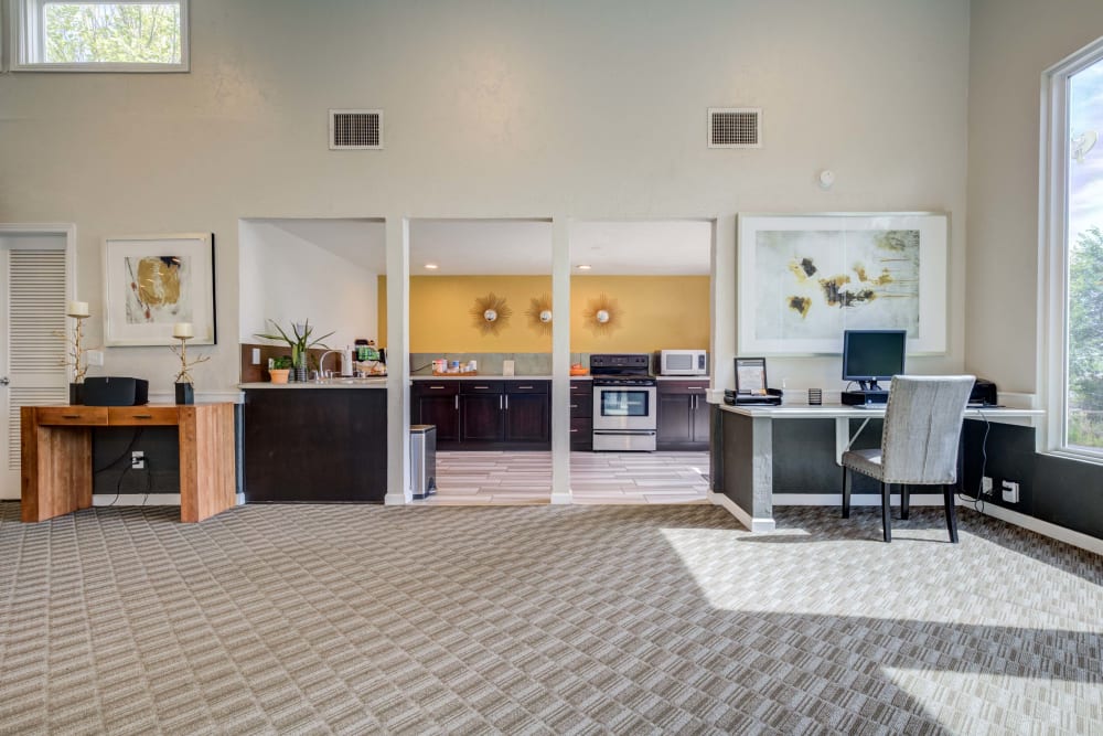 Interior of clubhouse featuring a community kitchen space and business center workstations at The Knolls at Sweetgrass Apartment Homes in Colorado Springs, Colorado