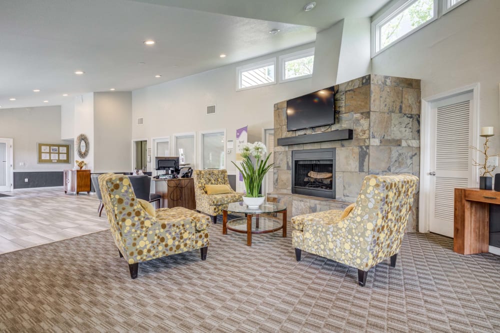 Comfortable seats by fireplace in clubhouse at The Knolls at Sweetgrass Apartment Homes in Colorado Springs, Colorado
